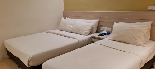 two beds sitting next to each other in a room at Star Tree Homestay -Contactless Self Check in in Kuantan