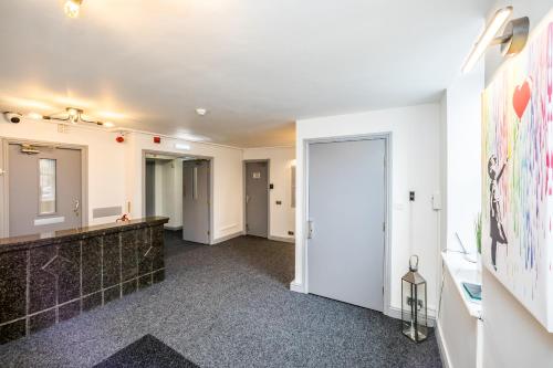 a hallway with white walls and a large hallway with a hallway at Huddersfield Central Lodge in Huddersfield