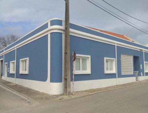 un edificio azul y blanco al lado de una calle en Casa Fisher, en Vendas Novas