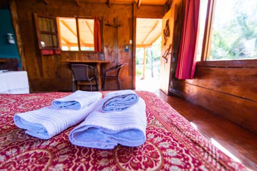 ein Zimmer mit einem Bett mit Handtüchern darauf in der Unterkunft Complejo Flores Azules in Olta