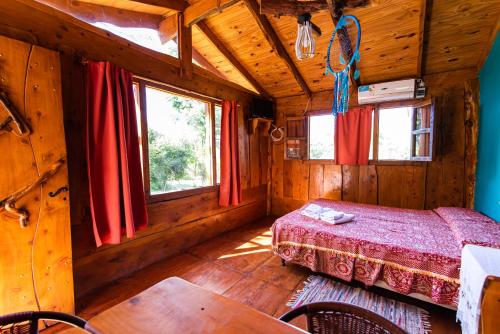 a bedroom with a bed in a wooden cabin at Complejo Flores Azules in Olta