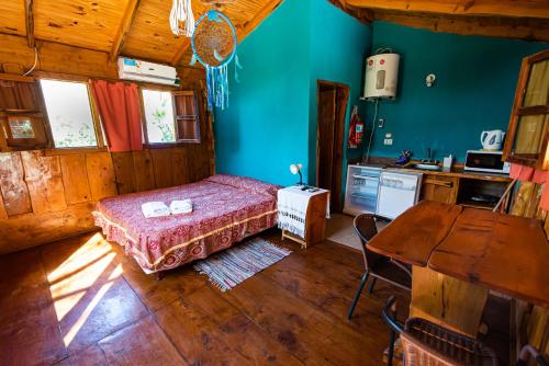 a bedroom with a bed and a table in a room at Complejo Flores Azules in Olta