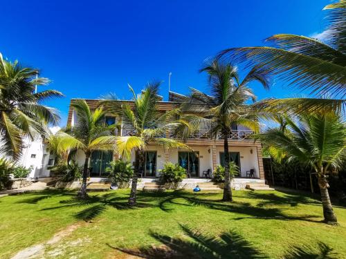 uma casa com palmeiras em frente em Hotel Camino Verde em Tolú