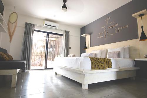 a bedroom with a large white bed and a window at Hotel Luna De Plata in Mahahual