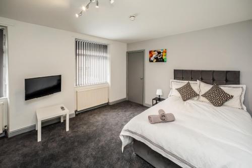 a bedroom with a bed and a flat screen tv at Huddersfield Central Lodge in Huddersfield