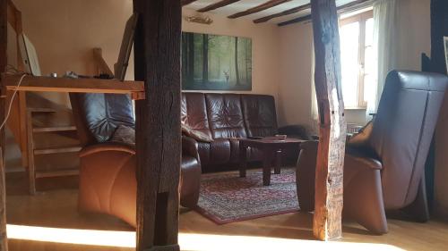 Una sala de estar con sofás de cuero y una mesa. en Historisches Haus im Herzen von Monschau, en Monschau