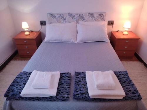 - une chambre avec un grand lit et 2 tables de chevet dans l'établissement Casa Loureira -Cabo do Mundo, Ribeira Sacra, à Rosende