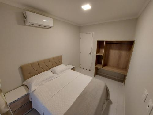 ein kleines Schlafzimmer mit einem Bett und einem Ventilator in der Unterkunft Lindo Apartamento no Muro Alto Condomínio Clube in Ipojuca