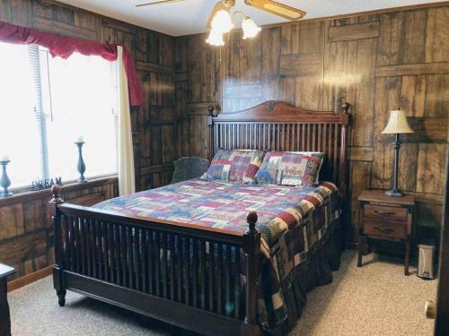 ein Schlafzimmer mit einem Bett in einem Zimmer mit Holzwänden in der Unterkunft Maggie’s lil Cottage in Sampson