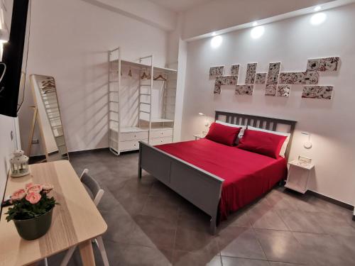 a bedroom with a red bed and a table at Octopus Vietri House in Vietri sul Mare