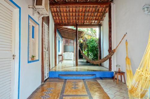 a porch with a hammock in a house at Tropicália Hostel e Pousada in Itacaré