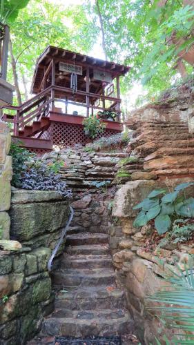 una escalera de piedra que conduce a un edificio en una pared de piedra en BENTON PLACE INN en Eureka Springs