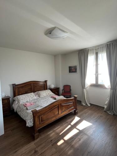 a bedroom with a wooden bed and a window at CASA AL VENTO in Cerreto Guidi