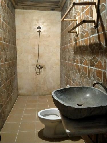 a bathroom with a sink and a toilet at Mengalung Bungalow in Kuta Lombok