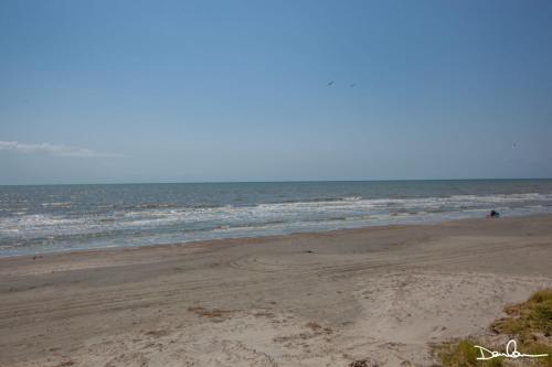an empty beach with the ocean in the background at Island Getaway in Galveston