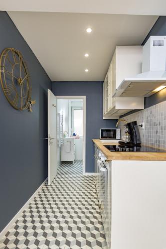 a kitchen with blue walls and a checkered floor at @Romantic Suite & Spa @Jacuzzi @ Parking gratuit @ in Mulhouse