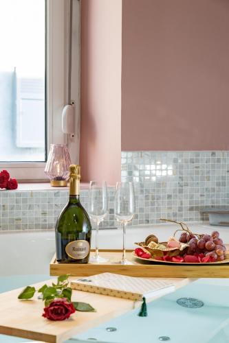 a bottle of wine on a cutting board with wine glasses at @Romantic Suite & Spa @Jacuzzi @ Parking gratuit @ in Mulhouse
