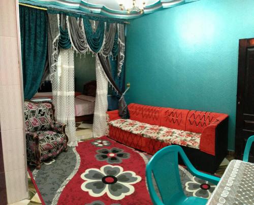 sala de estar con sofá rojo y alfombra roja en شقق وشليهات رشيد علي ضفاف بحيره قارون, en Shakshuk