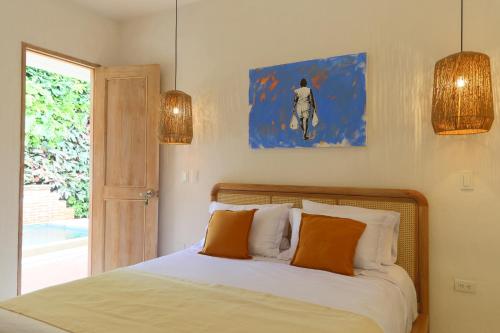 1 dormitorio con 1 cama con almohadas de color naranja y ventana en Casa Jaguar Hotel Boutique, en Cartagena de Indias