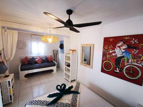 uma sala de estar com uma ventoinha de tecto e um sofá em Sahara Sands Guest House - Gili Trawangan em Gili Trawangan