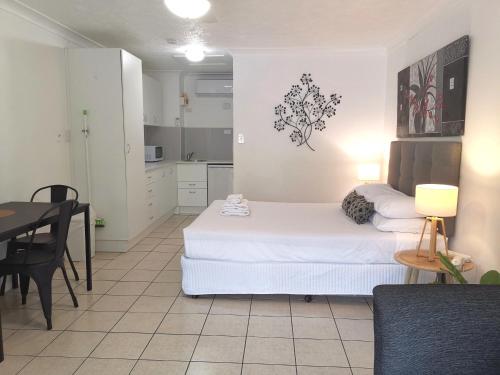 a room with two beds and a table and a kitchen at Bay of Palms in Gold Coast