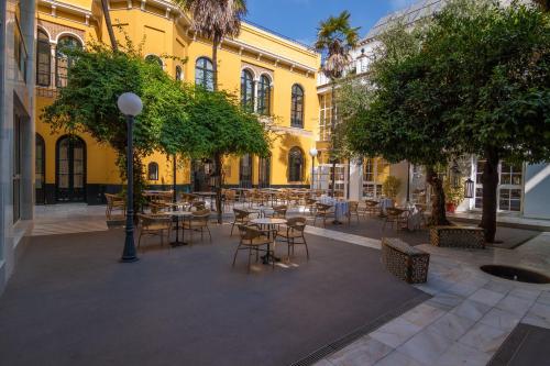 um pátio com mesas e cadeiras num edifício em San Gil em Sevilha