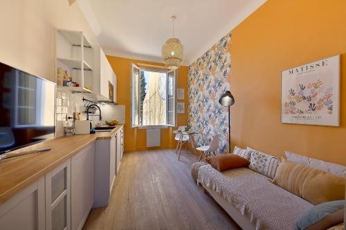 ein Wohnzimmer mit einem Sofa und einer Küche in der Unterkunft Cosycocoon La Bastide in Draguignan