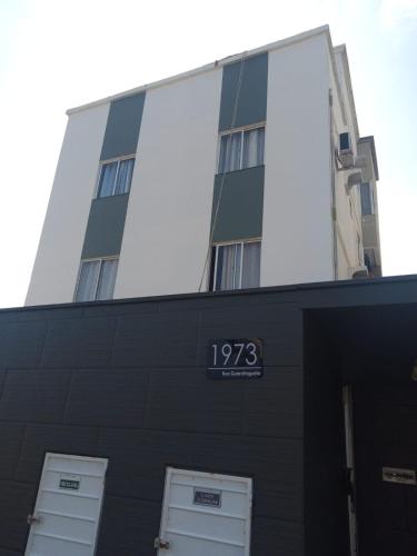 a building with a clock on the front of it at Apartamento Inteiro jardim Iririú in Joinville