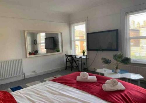 a bedroom with a large bed with towels on it at Balham, South London Spacious Guest House 5, 6 rooms available in London