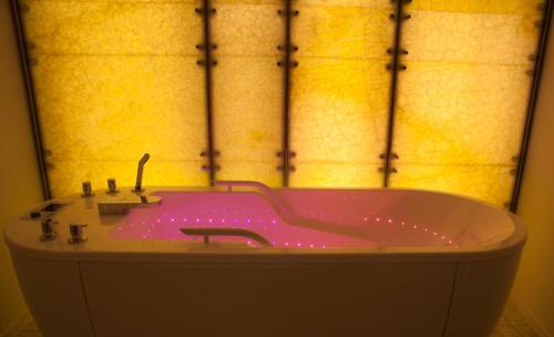 a bath tub with pink lighting in a bathroom at Hotel Bellevue in Mali Lošinj