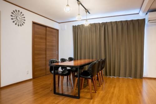 a dining room with a table and black chairs at neige furano Vacation rented house in Furano