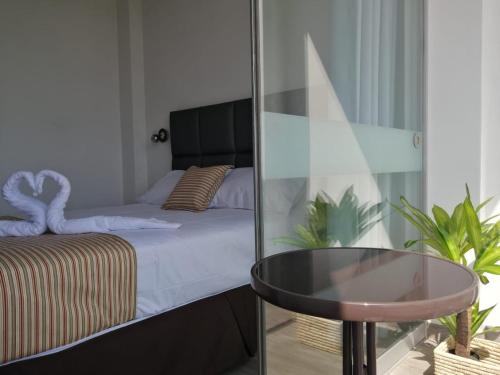 a bedroom with a bed and a glass table at Casa Yuraq Hotel Boutique in Chincha Alta
