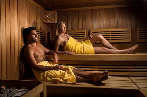a man and woman sitting in a sauna at See & Wellnesshotel Gerbi in Weggis