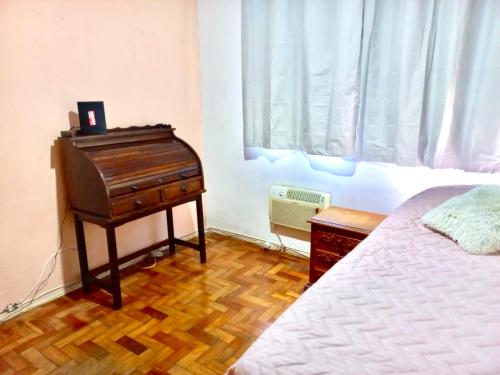 a bedroom with a piano sitting next to a bed at Aconchego no Rio in Rio de Janeiro