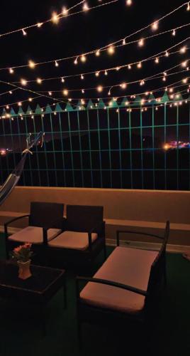 a patio with lights and chairs and a table at هتان السودة Hattan Al Soudah in Suda