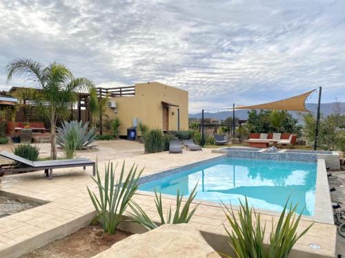 a swimming pool in a yard with a house at Luna Del Valle in Valle de Guadalupe