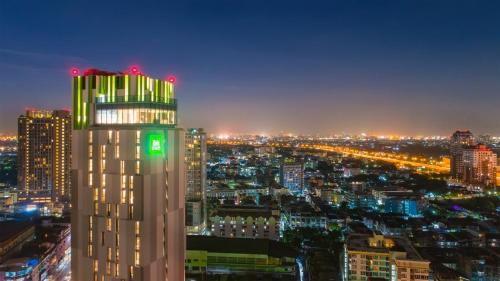 a city skyline at night with a tall building at ibis Styles Bangkok Sukhumvit Phra Khanong in Bangkok