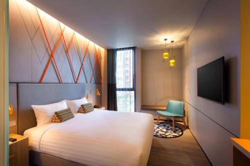 a hotel room with a bed and a television at ibis Styles Bangkok Sukhumvit Phra Khanong in Bangkok