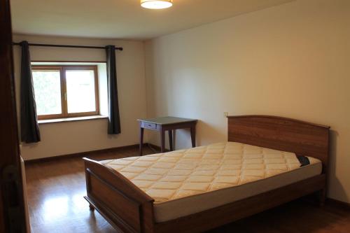 Schlafzimmer mit einem Bett, einem Fenster und einem Tisch in der Unterkunft Maison champêtre au coeur de la campagne in Fontaines