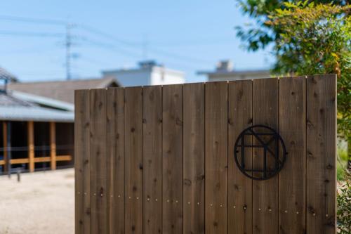 a wooden fence with a peace sign on it at OMISHIMA SPACE Omoya in Imabari