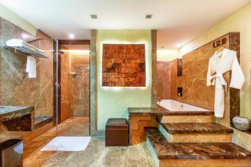 a bathroom with a tub and a sink and a shower at Flora Airport Hotel and Convention Centre Kochi in Nedumbassery
