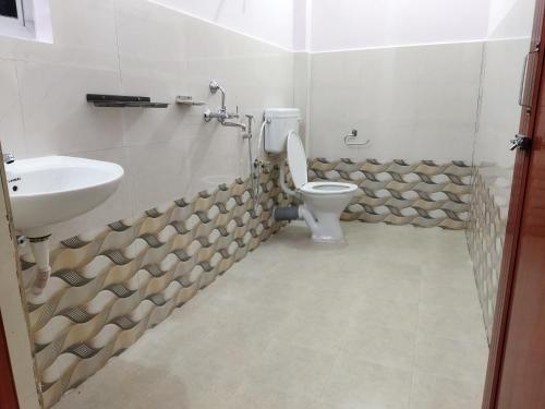 a bathroom with a toilet and a sink at The Leisure Home Stay in Shādipur