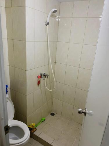 a bathroom with a shower with a toilet at The Studio Furnish Springlake Summarecon BCBD with an Amazing View for Healing in Rawabugel