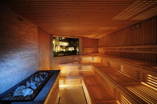 a sauna with a bench in a room with a window at Boutique Hotel Zum Rosenbaum in Nalles