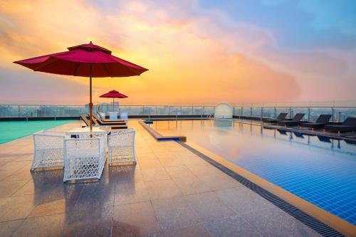 a pool with chairs and an umbrella on a building at Holiday Inn Dhaka City Centre by IHG in Dhaka
