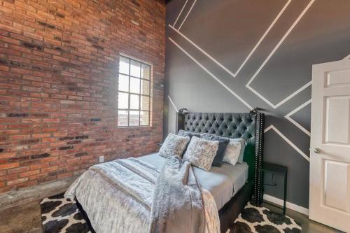 a bedroom with a brick wall and a bed at Detroit Skyline Luxe Loft 2-Bedroom w/2 Fireplaces in Detroit