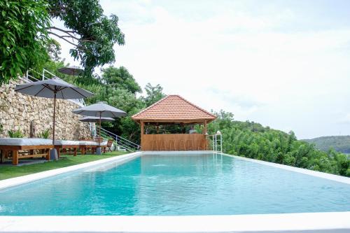 a swimming pool with a gazebo and a gazebo at Butterfly Villas Nusa Ceningan in Nusa Lembongan