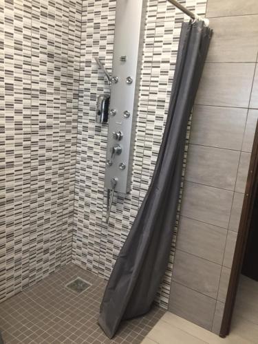 a shower with a black shower curtain in a bathroom at Ô cœur de l’île in Salazie