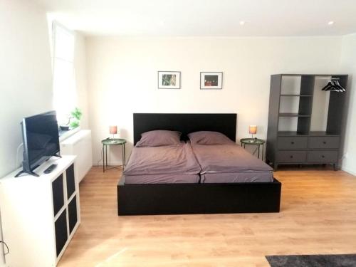 1 dormitorio con 1 cama y TV de pantalla plana en Apartment - Neu, modern, gemütlich, eigener Parkplatz en Colonia