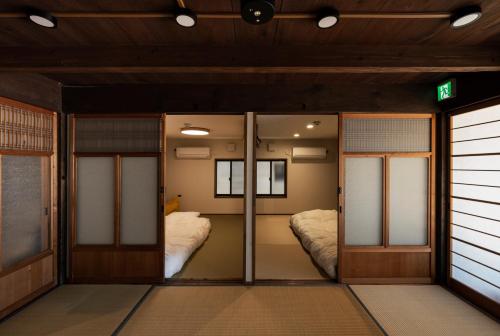 two beds in a room with glass doors at OMISHIMA SPACE Omoya in Imabari